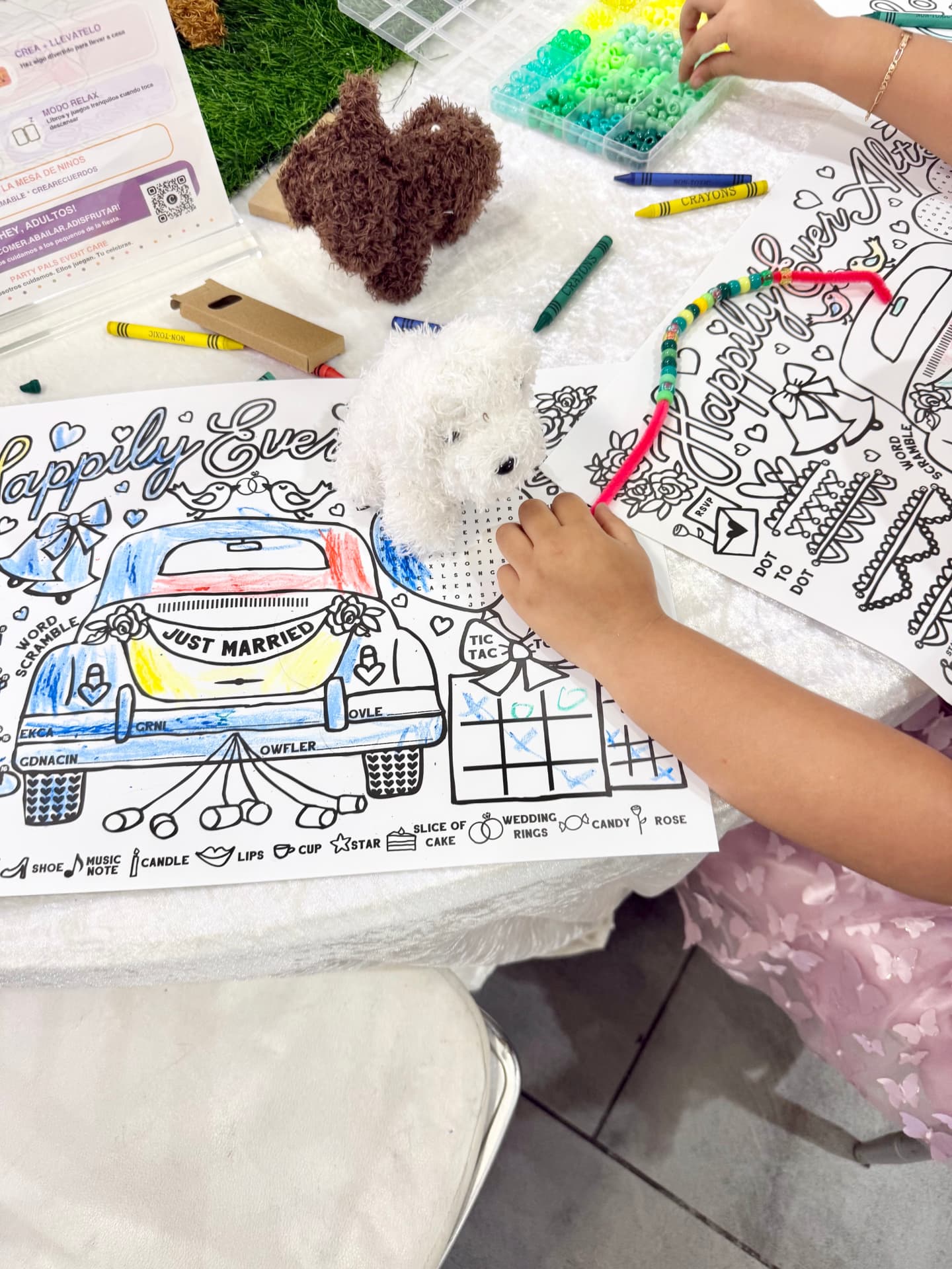 Kids coloring wedding-themed activity sheets with crayons